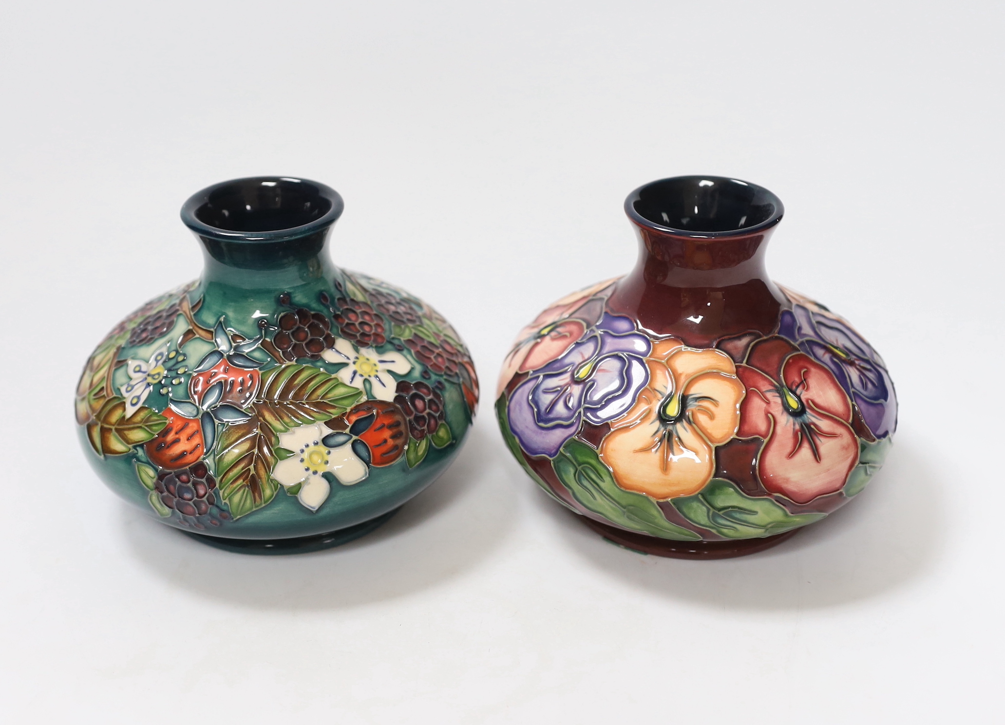 Two small Moorcroft squat vases, in Pansy and Carousel patterns, 10.5cm